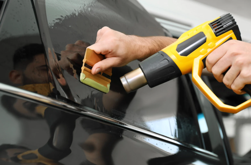 Heat Gun Being Used To Remove Bubbles From Car