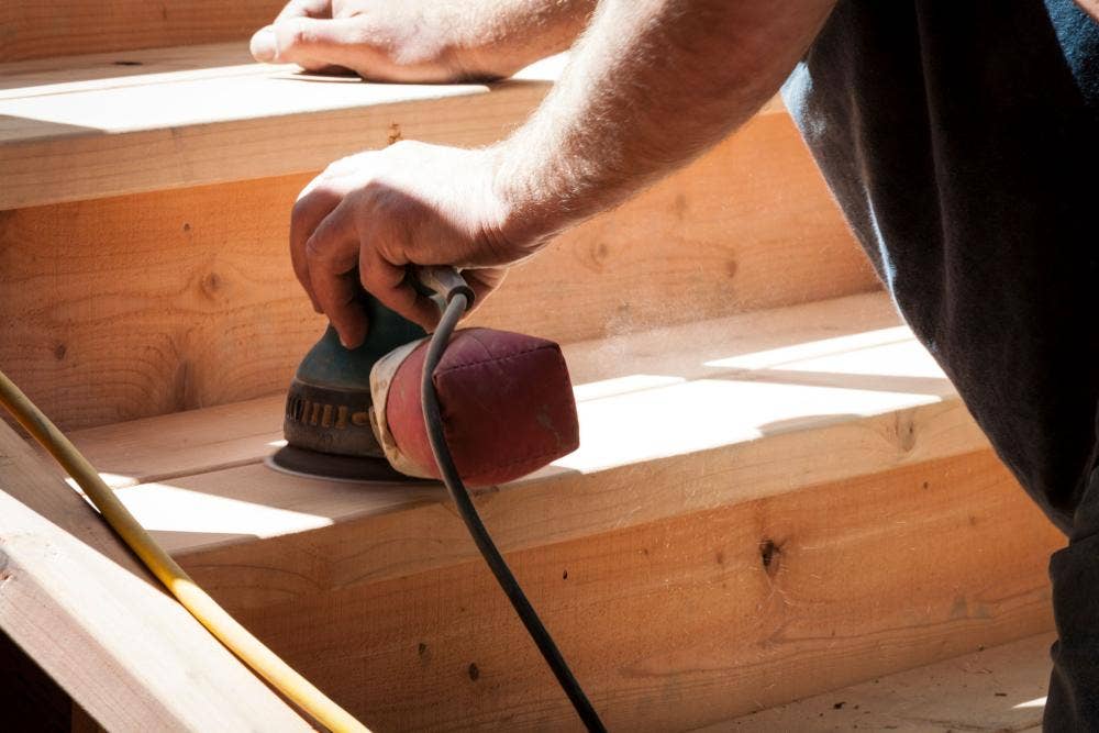 Somebody sanding a staircase