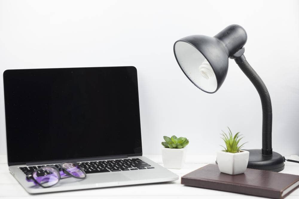 Desk lamp next to laptop